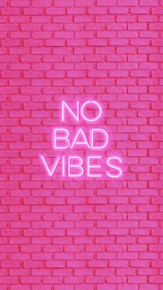 neon pink brick wall with the words no bad vibes on it