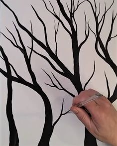 someone is drawing a tree with black branches