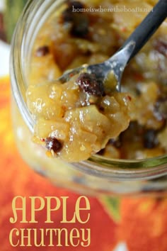 an apple chutney in a glass jar with a spoon