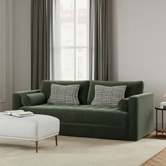 a living room scene with focus on the green couch and white footstool in the foreground