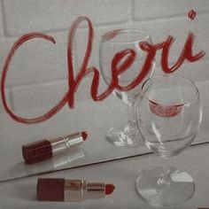 there is a wine glass and lipstick on the table