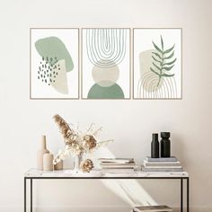 three abstract paintings hang on the wall above a table