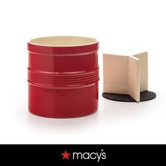 a red container with a white lid next to a black object