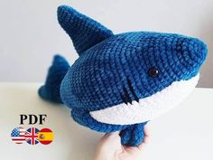 a hand holding a knitted stuffed shark toy with the caption pddf australia