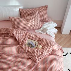 an orange and white checkered comforter on a bed