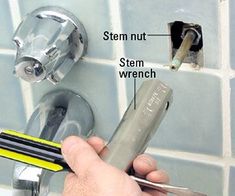 a person is using a wrench to fix a shower faucet