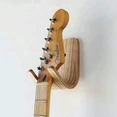 an electric guitar hanging on the wall with strings attached to it's back end