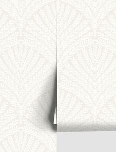 the corner of a white wallpapered room with a plant pattern on it's side