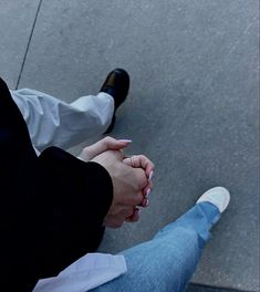 two people holding hands while sitting on the ground