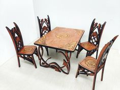 a wooden table and chairs with intricate designs on the top, set against a white background