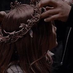 a woman is getting her hair done with a crown on top of her head,