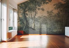 an empty room with wood flooring and large wall mural on the wall behind it