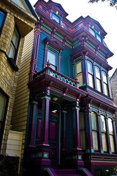 an old victorian style house painted in purple and green