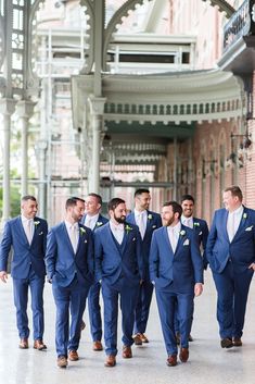 a group of men in blue suits walking together