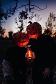 two pumpkins that are lit up in the dark