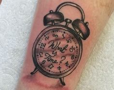 a tattoo with an alarm clock on the arm that says wake up and five o'clock