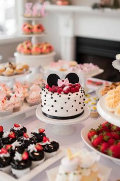 a table topped with lots of cakes and cupcakes