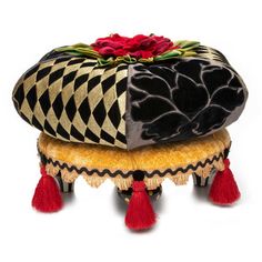 a black and gold ottoman with red tassels