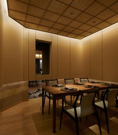 a long table with chairs and plates on it in the middle of a large room