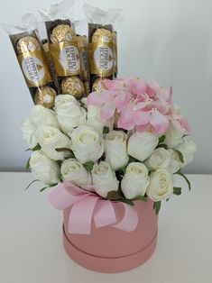 flowers and chocolates in a pink box on a table