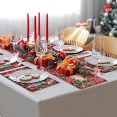 a table set for christmas dinner with red candles