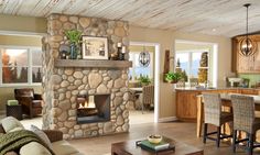 a living room filled with furniture and a fire place in the middle of a kitchen