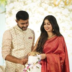 a man and woman cutting a cake together