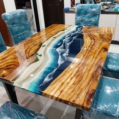 a glass table with blue chairs and an ocean scene painted on the top is shown