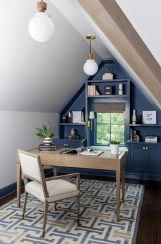 an attic office with blue painted walls and built - in shelving