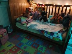 a child's bed with stuffed animals and toys on it in a room that is lit up