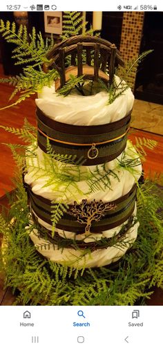 a three tiered cake with green plants on top