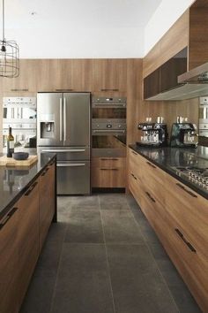 a modern kitchen with stainless steel appliances and wood cabinets