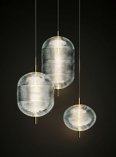 three glass lamps hanging from the ceiling in a dark room with black walls and flooring