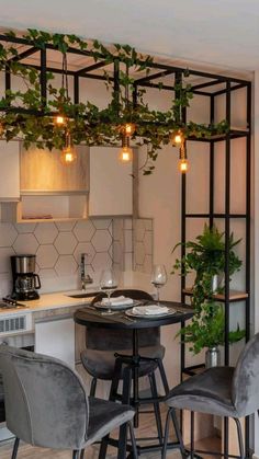 a kitchen with white cabinets and grey chairs