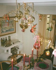 a dining room table with christmas decorations on it and candles in front of the chandelier