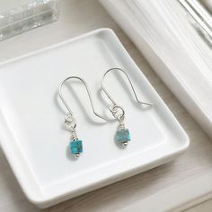 Indulge in the elegance of these Cube dangle earrings in sterling silver adorned with Turquoise Sea Sediment Jasper. Feel confident and sophisticated with these small, but stunning earrings that will elevate any outfit. Perfect for everyday wear or special occasions. Tarnish Resistant .940 Sterling Silver Approximately 1.25" long Genuine Turquoise Sea Sediment Jasper Gemstone Sent in a Ribboned Gift Box with Polishing Cloth Handmade in Montana Elegant Everyday Turquoise Earrings, Dainty Turquoise Earrings As Gift, Dainty Turquoise Earrings For Everyday, Everyday Turquoise Gemstone Earrings, Dainty Turquoise Earrings For Gift, Turquoise Sterling Silver Earrings With Ear Wire, Minimalist Hypoallergenic Turquoise Earrings, Sterling Silver Turquoise Single Earring, Dainty Nickel-free Turquoise Earrings