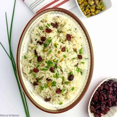 white rice with raisins and green onions in a bowl next to other dishes