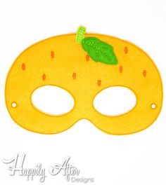 a yellow mask with a green leaf on it