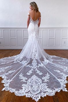 a woman in a wedding dress is standing on the floor with her back to the camera