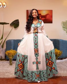 This breathtaking Habesha dress is made of luxurious Menen fabric in a deep shade of green, with a Tibeb bottom that adds a touch of traditional elegance. The Tibeb is a type of Ethiopian embroidery that features intricate geometric patterns and vibrant colors, and it is typically used to decorate the bottom part of the dress. The dress also features an intricate Tilf design that adds a touch of sparkle and glamour to the garment. The Tilf design is featured prominently on the bodice and sleeves Green Floor-length Dress For Traditional Ceremonies, Green Maxi Dress For Traditional Ceremonies, Green Dresses With Traditional Patterns For Ceremonies, Traditional Green Long Sleeve Maxi Dress, Traditional Long Sleeve Green Maxi Dress, Traditional Green Maxi Dress, Bohemian Maxi Dress With Traditional Patterns For Ceremonies, Green Floor-length Maxi Dress For Traditional Ceremonies, Green Long Sleeve Dresses For Traditional Ceremonies