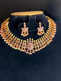 Description: This yellow gold color CZ necklace and matching earrings are lightweight and made with the highest quality craftsmanship. They are a stunning addition to any outfit and will make a perfect gift for any occasion. Features: Crystal stones Lightweight and elegant Can be paired with any dress, kurti, or saree Material: Cubic Zirconia (CZ) Stones Solitaire Necklace Ready to ship from California Free US standard shipping Ready to ship CARE INSTRUCTIONS: 1) Please keep your Jewelry away fr Gold Kundan Necklace With Gemstone For Puja, Diwali Temple Jewelry Sets With Gemstones, Gold Plated Temple Jewelry Sets, Temple Jewelry Sets With Gemstones For Diwali, Gold Ruby Temple Necklace, Temple Style Gold Plated Jewelry Sets For Celebration, Gold Ruby Temple Necklace For Diwali, Yellow Jewelry For Puja, Gold Ruby Kundan Temple Necklace