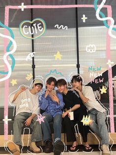 four young men sitting on a bench in front of a window with the words cut out