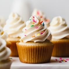 several cupcakes with white frosting and sprinkles