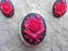 For sale are perfectly detailed, flawless (red rose with a single bud on a black background) cameo pendant silver plated LOCKETS!!!! Gorgeous!!! About 1 3/4" long!!! They hold two photos inside (or keepsakes). The French Earrings are also silver plated, about 1" long and very nice quality!!  They are offered at a reasonable price, make perfect gifts, and are wonderful quality!!!!  and the chain is 22" .925 silver plated 1.2mm snake chain, with a lobster claw clasp!!!! Please do visit my shop!!! Rose Red Roses Jewelry For Weddings, Elegant Black Jewelry With Rose Design, Rose Red Jewelry With Roses For Wedding, Valentine's Day Formal Jewelry With Roses, Rose Red Wedding Jewelry With Roses, Formal Valentine's Day Jewelry With Roses, Valentine's Day Formal Rose Jewelry, Black Necklace With Rose Design As Gift, Black Necklace With Rose Design For Gift