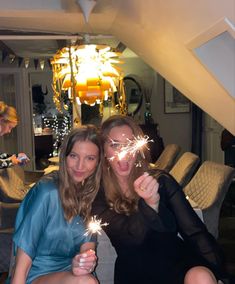 two women pose with sparklers in their hands