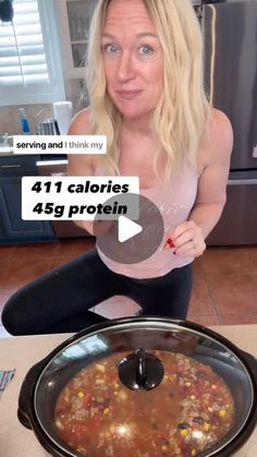 a woman sitting on the floor in front of a crock pot filled with food