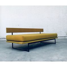 a yellow couch sitting on top of a cement floor