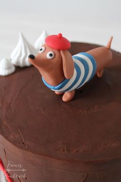 a chocolate cake with a dog figurine on top