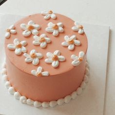 a pink cake with white flowers on it