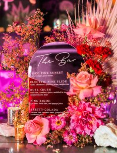 the bar sign is surrounded by flowers and candles